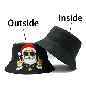 Détail d'un chapeau bob réversible noir avec imprimé Père Noël et doublure intérieure unie