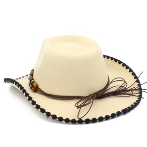 Dettaglio cappello cowboy beige con bordi seghettati neri e cordino con perle occhio di tigre