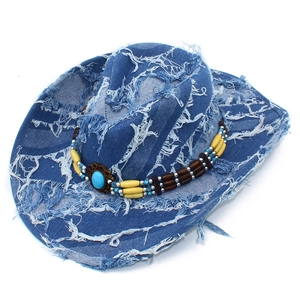 Dettaglio di un cappello da cowboy in denim blu con perline etniche e bordi sfrangiati