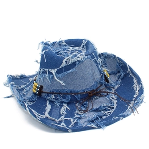 Dettaglio cappello cowboy in denim blu con bordi sfrangiati ed eleganti perline colorate