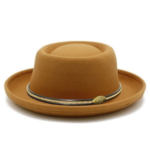 Dettaglio cappello pork pie cammello con nastro nero, catena metallica e stemma vintage