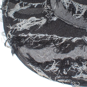 Detail shot of distressed denim cowboy hat brim with frayed edges and texture