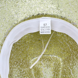 Detail of size 57 label and 100% polyester fabric on gold sequin party cowboy hat