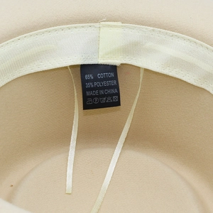 Dettaglio della fodera interna del cappello con etichetta 65% cotone e 35% poliestere