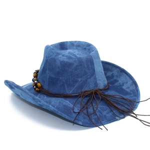 Detail of blue denim cowboy hat featuring brown cord with wooden beads decoration