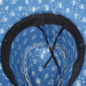 Close-up of blue denim hat interior with silver sequins, sweatband and dual adjusters