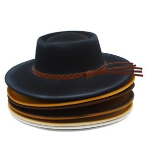 Stack of felt fedora hats in gradient colors with woven leather bands and tassel detail