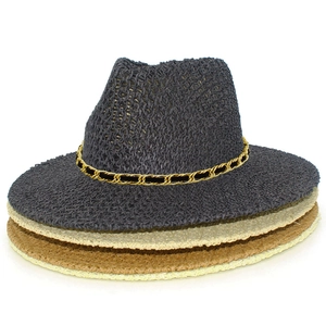 Detail of stacked woven fedora sun hats featuring stylish gold chain link decoration
