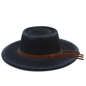 Detailed view of wide brim navy felt hat featuring a brown leather braided band and tassel