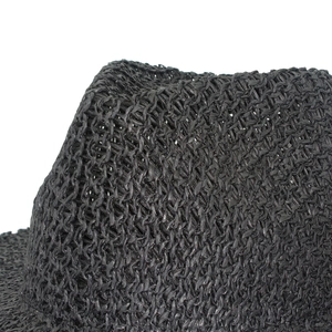 Gros plan sur la texture de paille tressée noire d'un chapeau d'été élégant et aéré