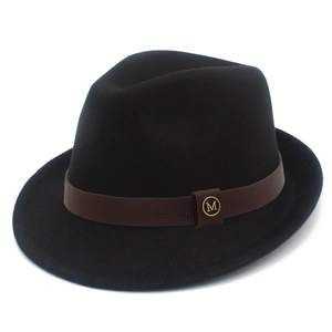 Detailed close-up of a black fedora hat with brown leather band and golden M logo detail