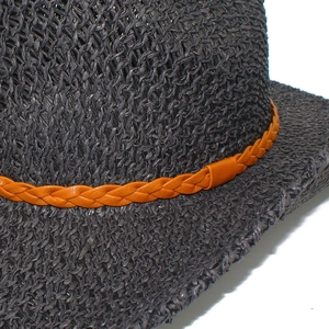 Detailed close-up of dark grey woven straw hat with orange-brown braided leather band