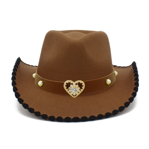 Dettaglio di un cappello fedora marrone con emblema a cuore dorato e cinturino in pelle