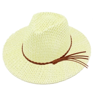 Detailed macro view of woven straw texture and decorative brown leather tassel on the sun hat