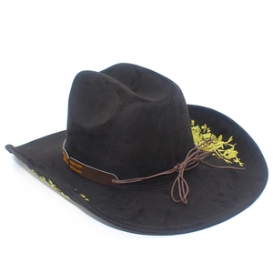 Detailed close-up of golden floral embroidery on a dark brown suede cowboy hat