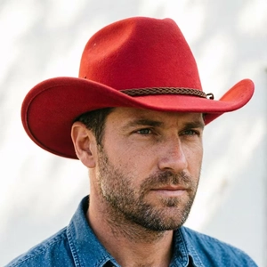 Detail of red felt cowboy hat featuring a brown braided leather band and metal buckle