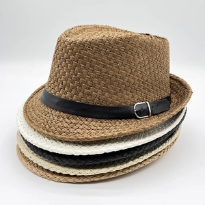 Detail view of stacked summer straw fedora hats in brown, white, black and beige colors