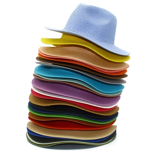 Stack of colorful straw panama hats showing detailed weave texture and various color options