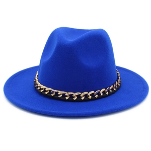 Détail d'un chapeau fedora bleu roi en laine avec une chaîne décorative dorée et noire