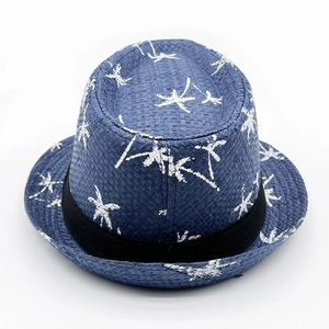 Detail showing the fine straw weave and white coconut tree pattern on navy blue fedora hat