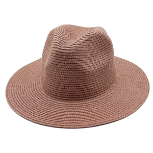Macro view of the spiral woven texture on a tan Panama straw sun hat with fedora crown