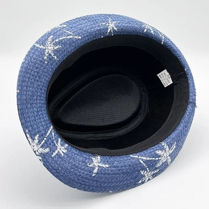 Detail view of the 100% paper interior, size 58 label, and blue straw hat texture