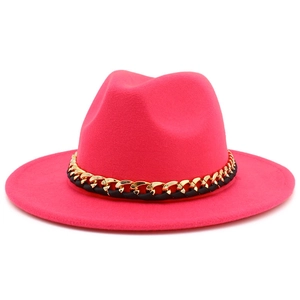 Détail de la chaîne en métal doré et du ruban noir sur un chapeau fedora en laine magenta