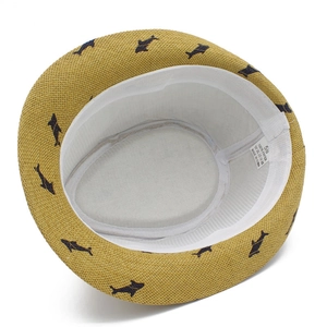 Sombrero de paja amarillo con estampados de delfines azules visto desde arriba
