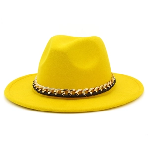 Détail d'un chapeau en laine jaune avec une chaîne décorative dorée et noire tressée