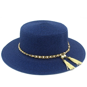 Dettaglio cappello di paglia blu navy con catena dorata, perle e nappine eleganti