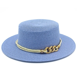Detail of light blue straw boater hat with ivory woven rope and gold metal chain accents