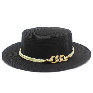 Detail of woven texture on black boater hat with gold chain and cream rope trim
