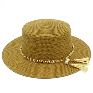 Dettaglio cappello di paglia da donna con catena d'oro con perle e nappe bianche