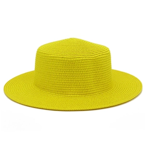 Dettaglio dell'intreccio in paglia ad alta densità su un cappello da sole giallo a tesa larga