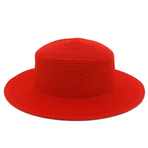 Dettaglio di cappello paglia rosso con trama a spirale fine e tesa larga rigida
