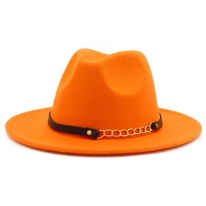 Detail of orange wool fedora featuring black leather band and golden chain accents