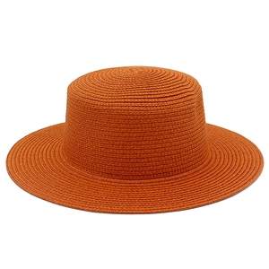 Vista macro del cappello di paglia arancione con trama a spirale e tesa piatta fissa
