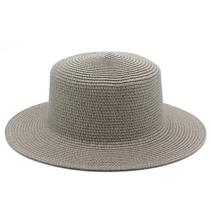 Dettaglio ravvicinato della trama fine di un cappello da sole in paglia intrecciata beige