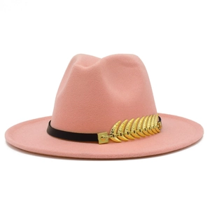 Detail of pink fedora hat featuring a black leather band and golden leaf buckle ornament
