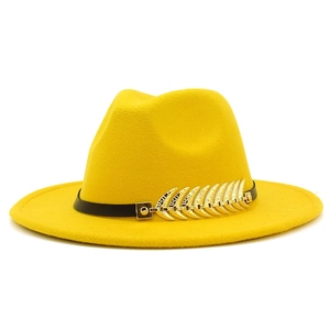 Detail of a bright yellow fedora hat featuring a black band and gold feather metal buckle