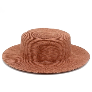 Dettaglio della trama fitta di un cappello di paglia estivo marrone rossiccio a tesa larga