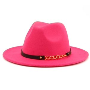 Detail of rose red fedora hat with black leather strap and gold chain accent