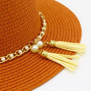 Elegante cappello di paglia arancione con catena di perle dorate e nappe gialle