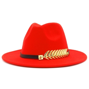Close-up of red fedora hat featuring a black band and gold feather metal accessory