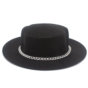 Detail of black flat-top straw sun hat featuring a stylish silver metal chain band decoration