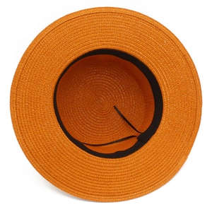 Close-up of bright orange straw hat detail showing woven texture and adjustable inner strap
