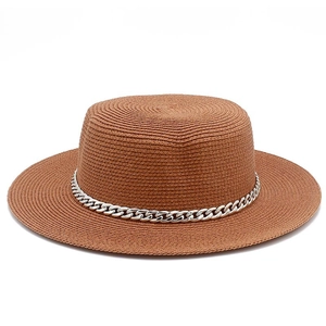 Detail of woven straw boater hat featuring a stylish silver metal chain decoration