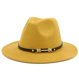 Detailed close-up of yellow wool fedora hat with black leather band and gold buckle