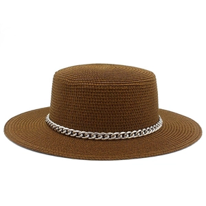 Detailed shot of brown straw sun hat with woven texture and decorative silver chain