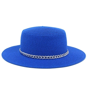 Detail of blue straw hat featuring woven texture and decorative silver chain band